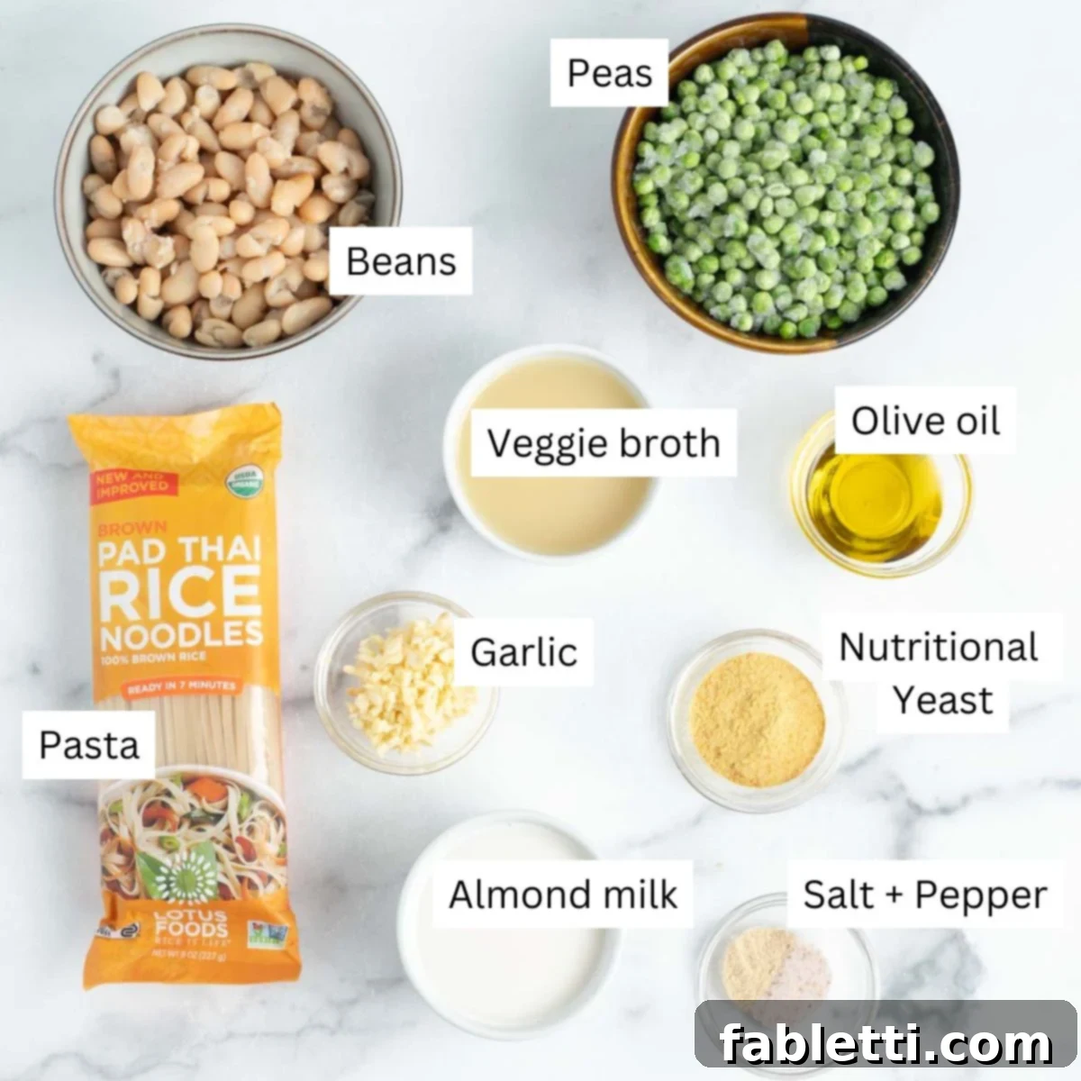 Labeled ingredients for dairy-free Fettuccine Alfredo: pasta, peas, garlic, nutritional yeast, broth, almond milk, salt, and pepper.