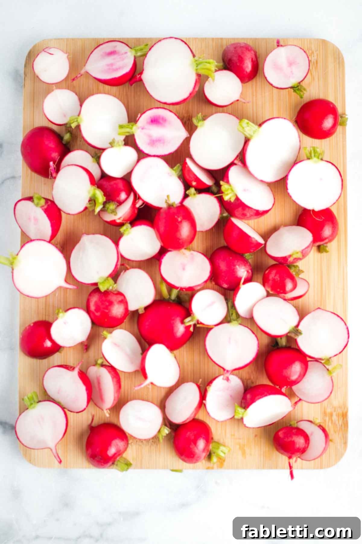 Roasted Radishes with Pistachio-Parsley Drizzle 4 Radishes cut in half on a wooden board.