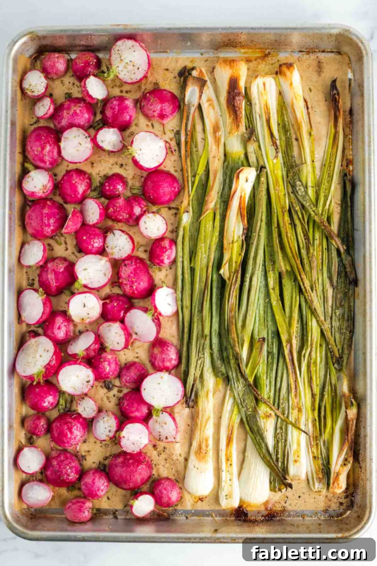 Roasted Radishes with Pistachio-Parsley Drizzle 7 Roasted red radishes and scallions on a large parchment lined rimmed baking sheet.